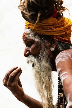 an old man with long white hair and beard wearing a yellow turban on his head