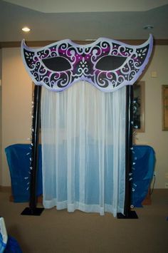 a purple and black masquerade mask sitting on top of a pole in front of a window