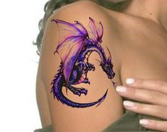 a woman's arm with a purple dragon tattoo on the side of her shoulder