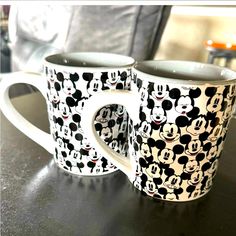 two mickey mouse mugs sitting on top of a table