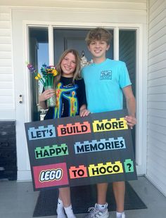 two children holding up a sign that says build more happy memories to hoco?