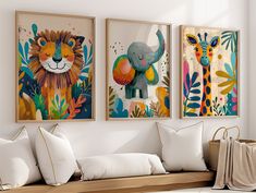 three animal paintings hang on the wall above a couch with white pillows and throw pillows