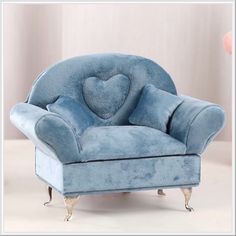 a blue chair with a heart shaped pillow on it