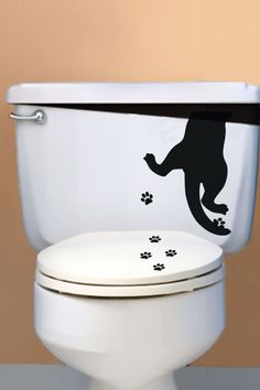 a toilet with a sticker on the lid and paws painted on it's side