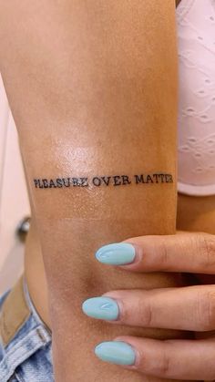 a woman's arm with the words pleasure over matter tattooed on her left arm