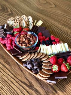 a platter filled with fruit, crackers and nuts