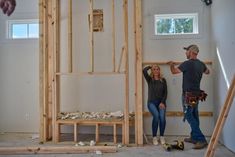 a man and woman standing in a room under construction