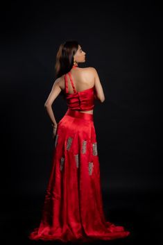 Adding a touch of royal elegance and grace to weddings and festivities, this stunning scarlet-red lehenga is a must-have! The cupro satin fabric is soft and lightweight, making it perfect for twirling around the dance floor. The intricate hand-embroidered mirror work adds a unique sparkle to your look.Details Neckline: Halter neck Material: Cupro satin Lining: Cotton-polyester Made in India Material This outfit is made with cupro satin; the fabric is made from cotton linter wasteIt is a sustainable alternative to polyester Elegant Red Raw Silk Pre-draped Saree, Festive Satin Pre-draped Saree For Formal Occasions, Satin Pre-draped Saree For Wedding, Red Art Silk Gown For Navratri, Red Lehenga With Pallu For Evening, Floor-length Cutdana Choli For Evening, Red Cutdana Party Wear Sets, Evening Floor-length Cutdana Sets, Elegant Red Tissue Silk Choli