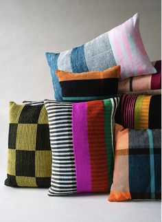 four colorful striped pillows stacked on top of each other in different sizes and colors,