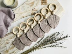 six pairs of wooden rings with tassels on them next to some lavender flowers