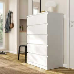 a white dresser sitting next to a window in a room with wooden floors and walls