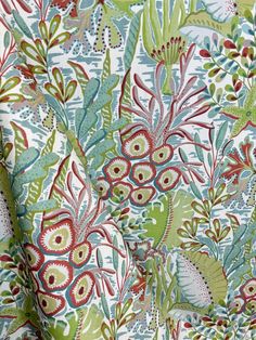 an upholstered fabric with colorful flowers and leaves on white, green, red and blue colors