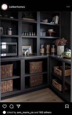 a kitchen with black cabinets and wicker baskets