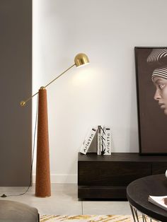 a lamp that is on top of a table in a room with a painting and other items