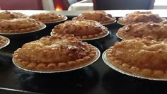 several pies sitting on top of a black tray