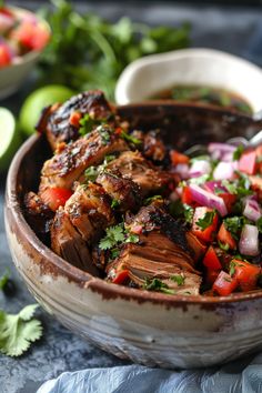 a bowl filled with meat and veggies on top of a table