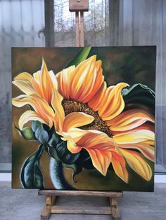 a painting of a yellow sunflower on an easel