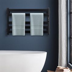 two towels are hanging on the wall above a bathtub in a bathroom with blue walls