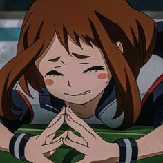 an anime character with red hair and brown eyes sitting in front of a green table