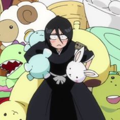 a woman in a black dress is surrounded by stuffed animals