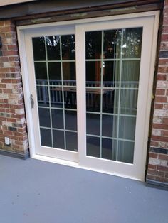 an open sliding glass door in front of a brick building