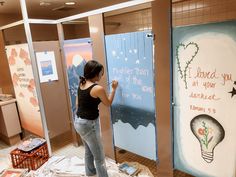 a woman is standing in front of some posters