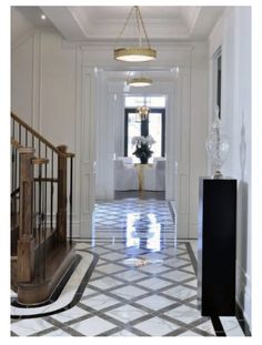 an elegant hallway with white walls and marble flooring