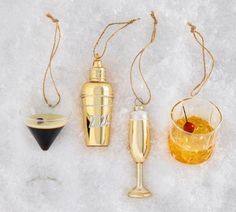 three different types of wine glasses and a bottle on the snow covered ground, with one being filled with liquid