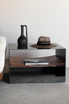 a table with a hat on it next to a bed