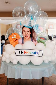 a woman is sitting in front of balloons with her name on it and some stuffed animals