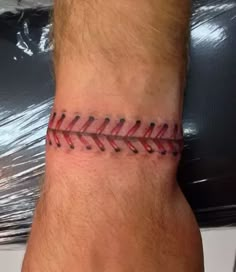 a man with a baseball tattoo on his wrist