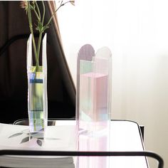 a vase with flowers in it sitting on a table next to a stack of books