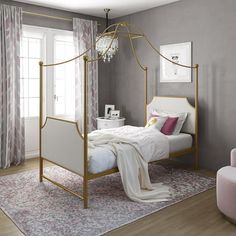 a white bed sitting in a bedroom next to a pink chair and window with curtains