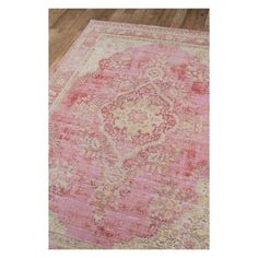 a pink and beige rug with an ornate design on the middle, in a room