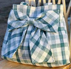 a green and white checkered bag sitting on top of a wooden chair with a bow