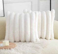 a bunch of white pillows sitting on top of a couch