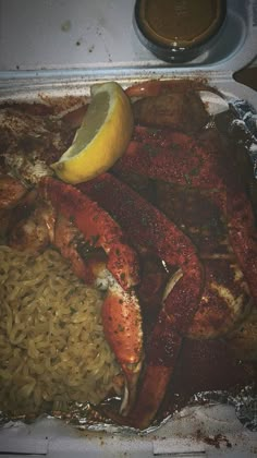 cooked lobsters and rice with lemon on the side