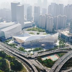 an aerial view of a large building in the middle of a city with lots of traffic