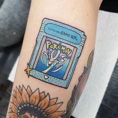 a person with a tattoo on their arm has a pokemon card in front of them