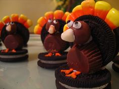 chocolate turkey cookies with candy candies in the shape of their heads and legs, on a table