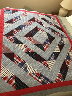 a bed with a red, white and blue quilt on it