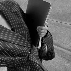 a person in a suit and tie holding a laptop