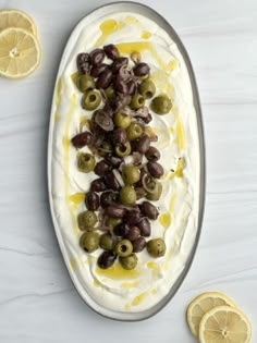 olives and whipped cream on a platter with lemon slices