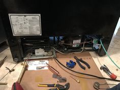 there are many tools on the table and in front of the heater that is being worked on