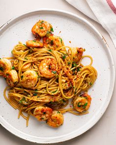 a white plate topped with pasta and shrimp