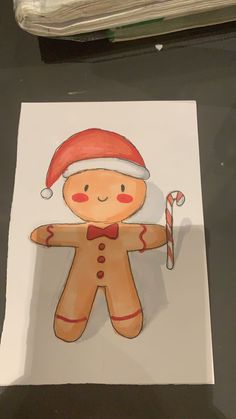 a drawing of a ginger with a santa hat and candy cane on it's arm