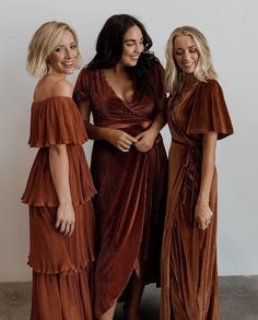 three women standing next to each other in brown dresses and one is holding her hand on her hip