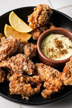 fried food with dipping sauce on a black plate