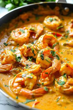 a pan filled with shrimp and sauce on top of a table