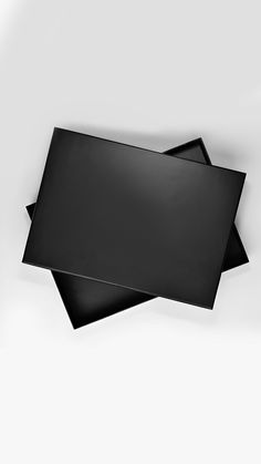 three blank black cards laying on top of each other in front of a white background